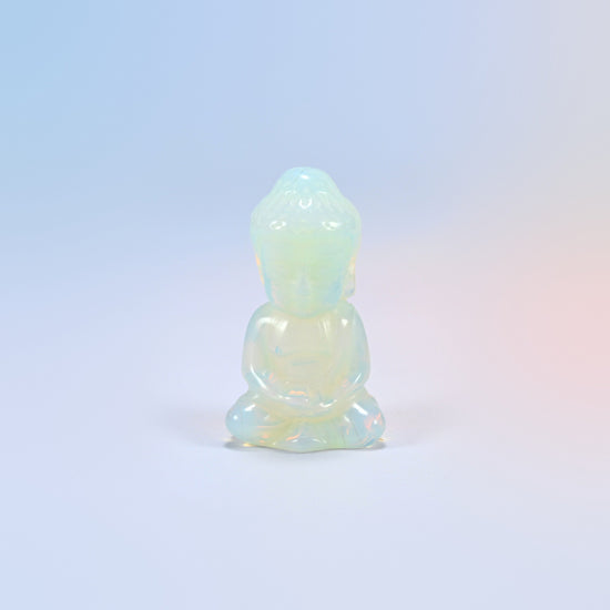 Opalite sitting Buddha carving with a milky glow and a soft blue sheen, man-made glass