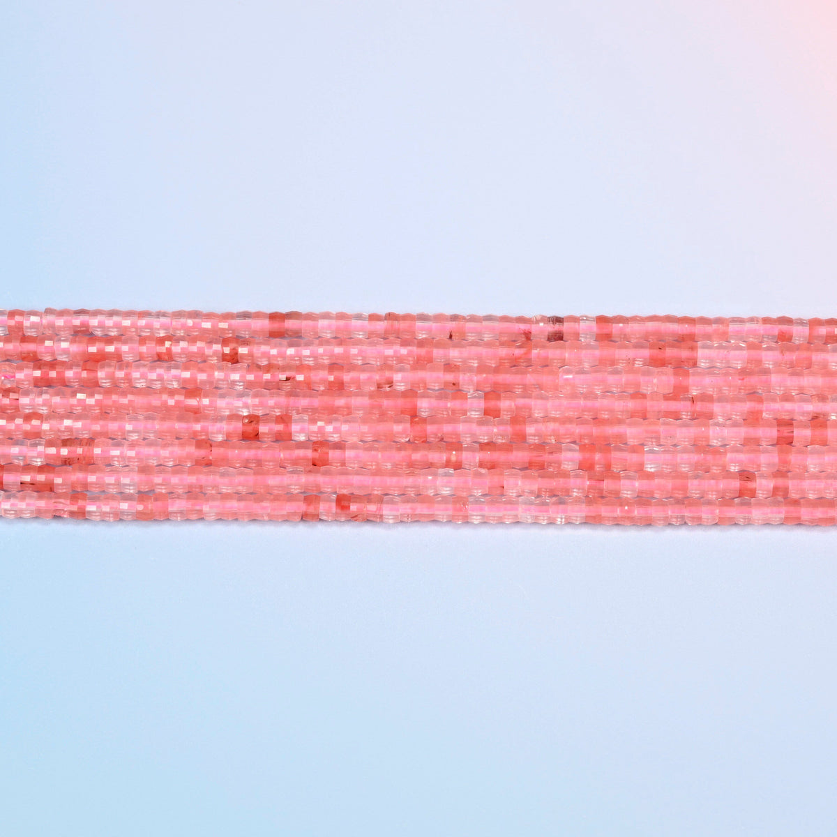 Several strands of melon quartz faceted heishi disc beads laid in straight rows