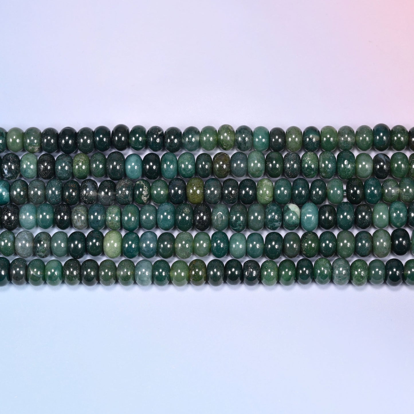 Close-up horizontal row of Moss Agate beads showing the soft green mossy inclusions.