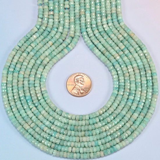 Green amazonite faceted heishi disc strands formed into a teardrop loop around a US penny for scale