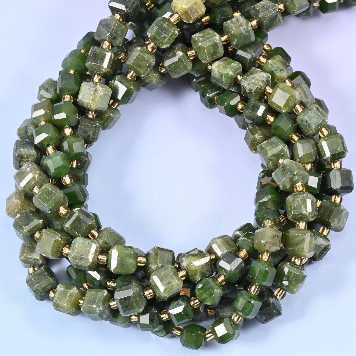 Deep olive and forest green cubes, semi-translucent with paler streaks and cloudy patches running through the stone.