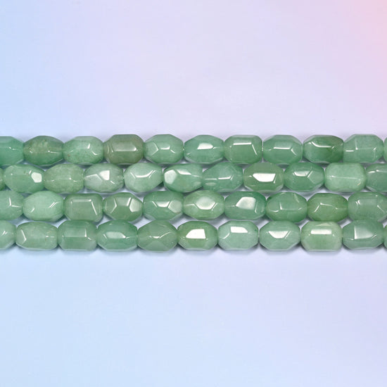 Close-up rows of green faceted Aventurine barrel beads laid diagonally, showing the sage green color variation and facet cuts.