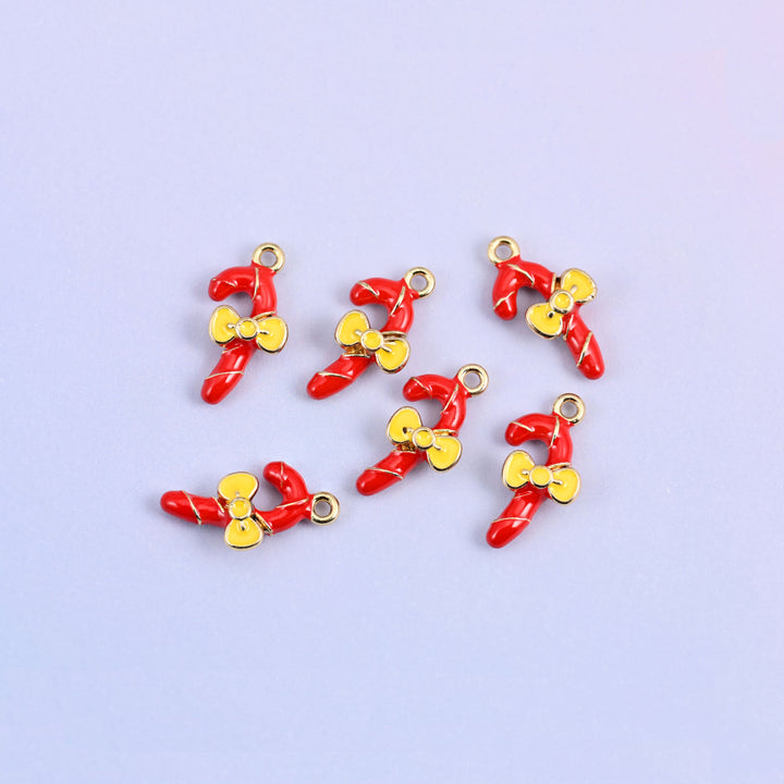 Seven red candy cane charms scattered in a group, enamel over 18K gold plated brass with yellow bows.