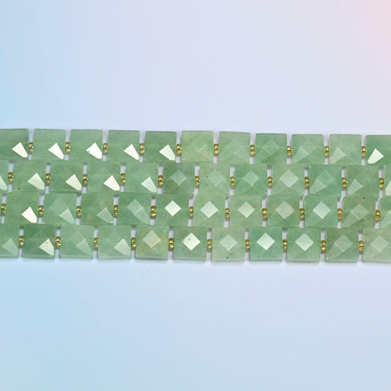 Several strands of natural green aventurine faceted flat square beads laid in straight rows