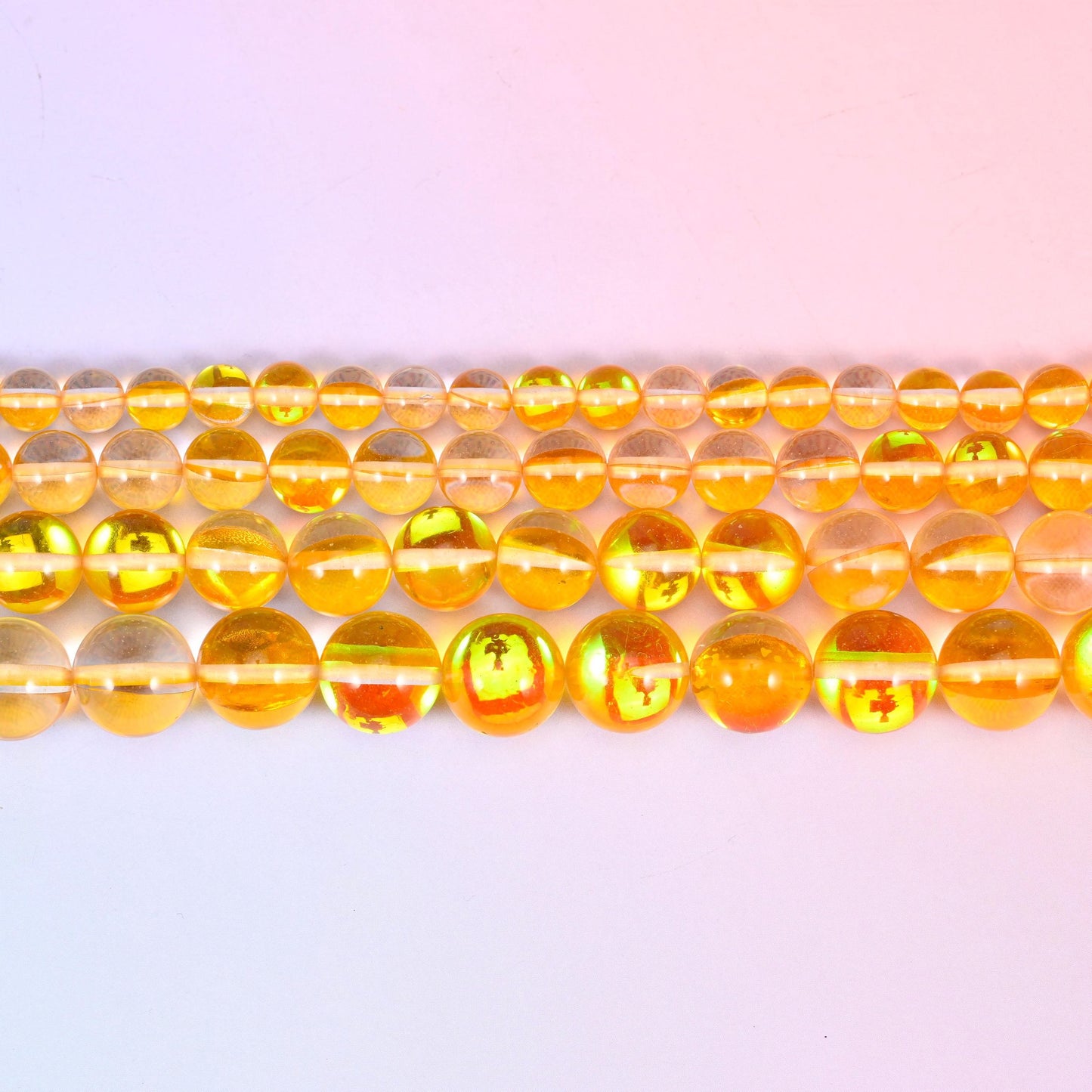 Mystic Aura Yellow Round Glass Beads in clear golden-amber with a green, pink and gold aura flash