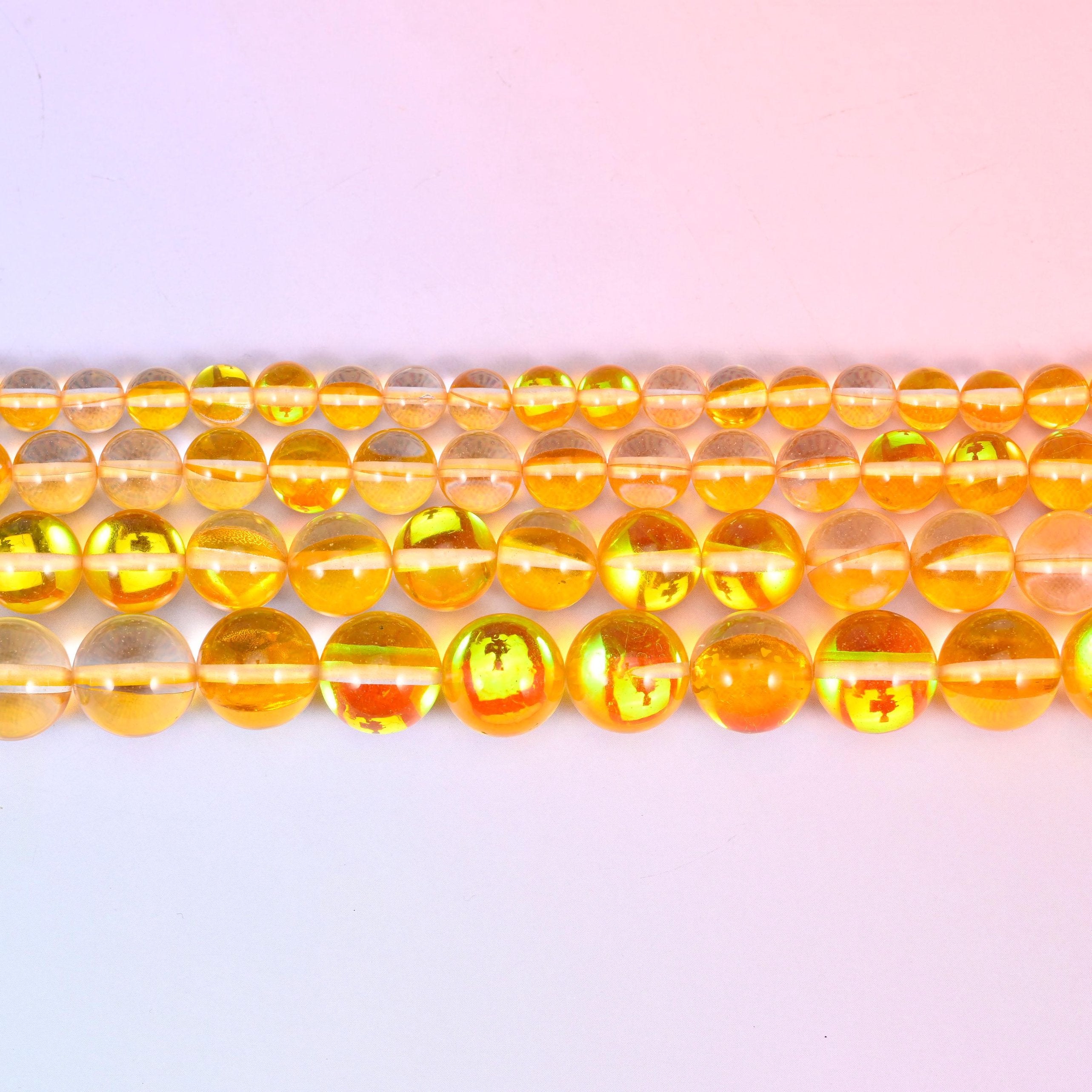 Mystic Aura Yellow Round Glass Beads in clear golden-amber with a green, pink and gold aura flash