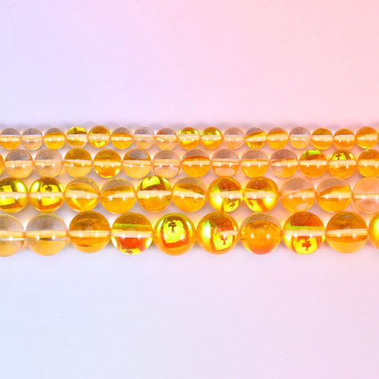 Mystic Aura Yellow Round Glass Beads in clear golden-amber with a green, pink and gold aura flash