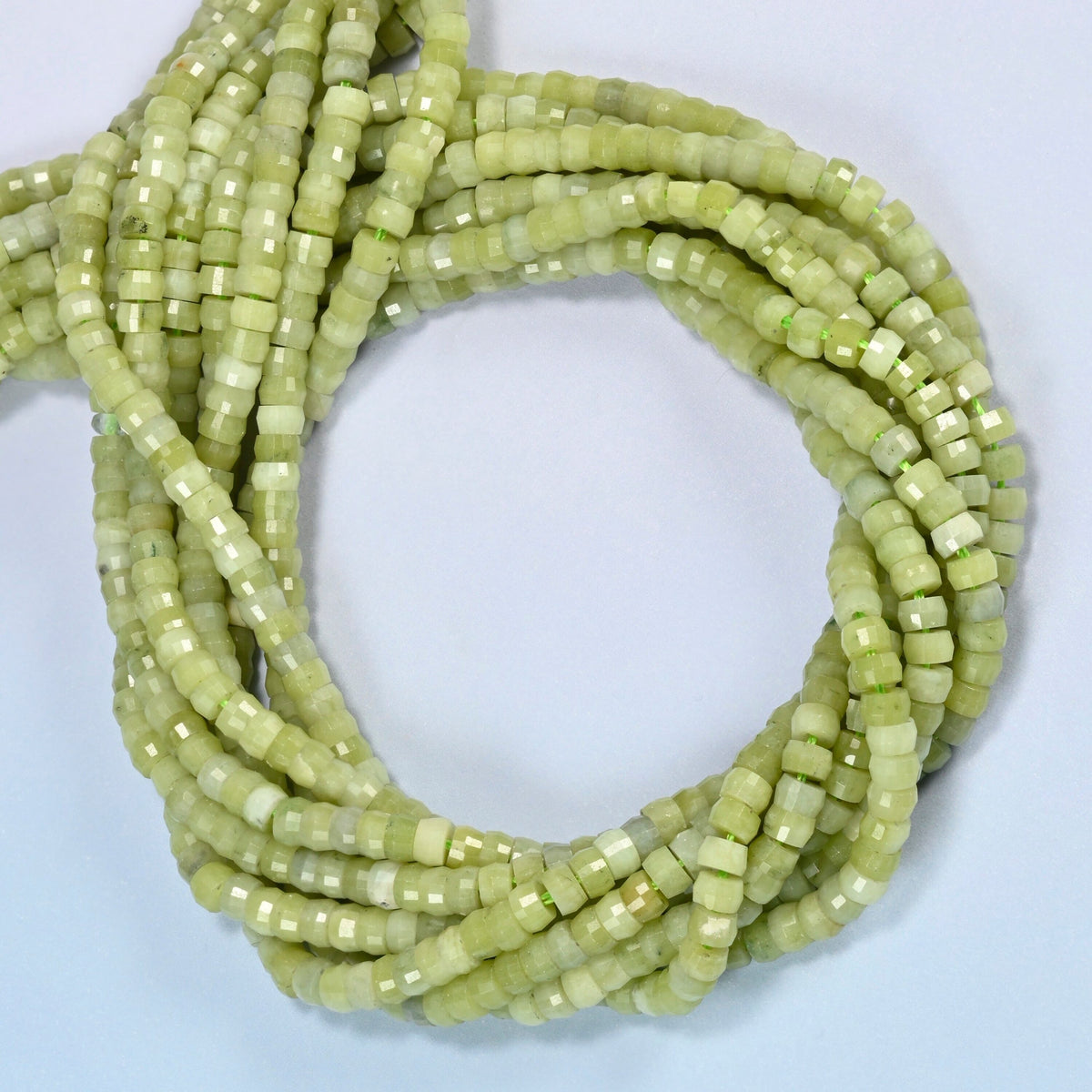 South Jade faceted heishi disc beads coiled into overlapping loops, whole strands of light green stone
