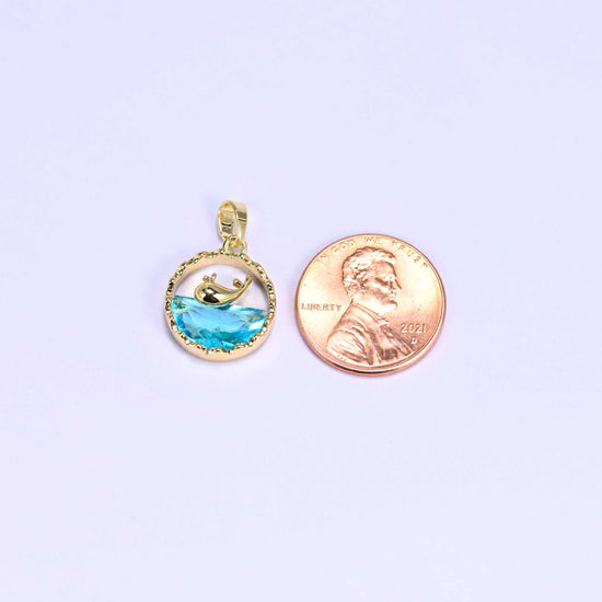 Whale charm with a gold whale silhouette diving into a faceted blue zirconia wave