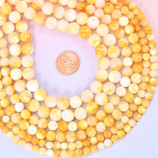 Yellow Pearl Shell Round Beads — golden honey and cream shell with the soft pearly lustre and fine natural banding you only get from mother of pearl, polished into clean rounds.