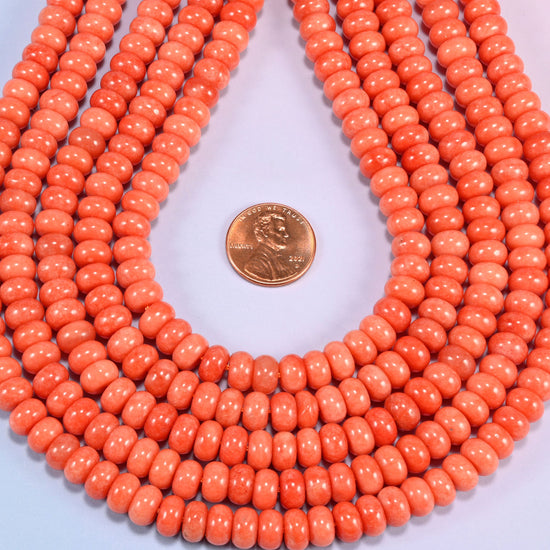 Red Orange dyed jade gemstone rondelle beads in a teardrop coil, warm orange discs stacked close together