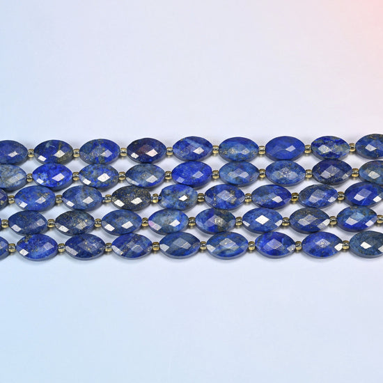 Several strands of lapis lazuli faceted flat oval beads laid in straight rows with gold seed bead spacers