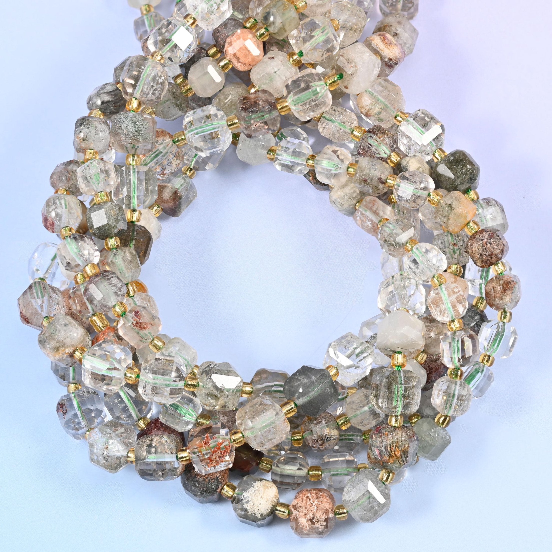 Clear to smoky quartz cubes with phantom clouds suspended inside them, drifting through mossy green, rust brown and pale grey.