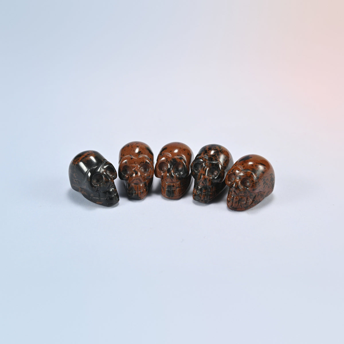 1 inch skull crystal carving in golden swan, red-brown natural stone with dark speckles