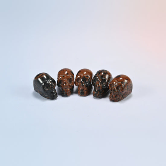 1 inch skull crystal carving in golden swan, red-brown natural stone with dark speckles