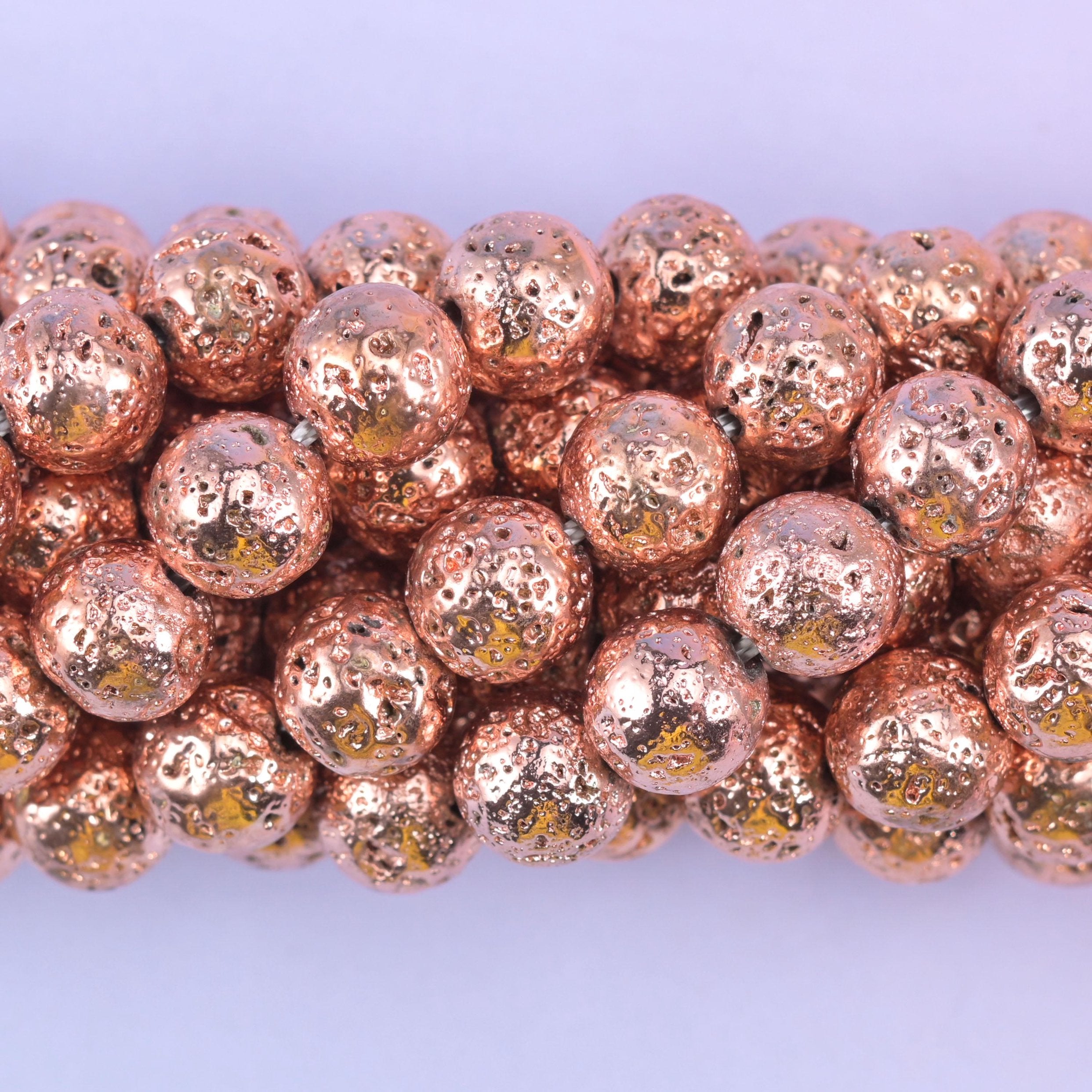 Round cut volcano rock lava beads with a porous, rose gold coated surface