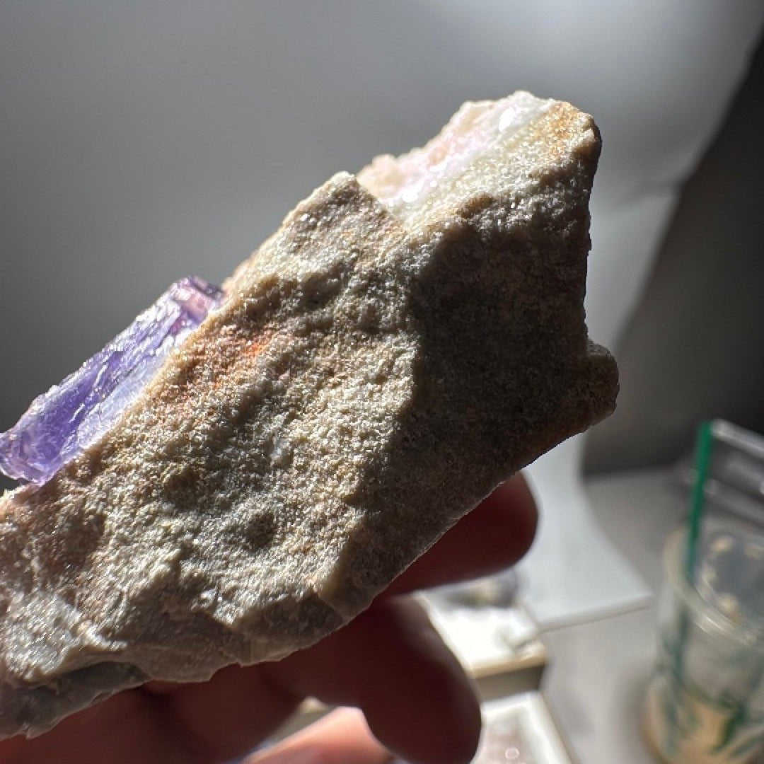 The specimen tilted to show its thickness and the rough underside