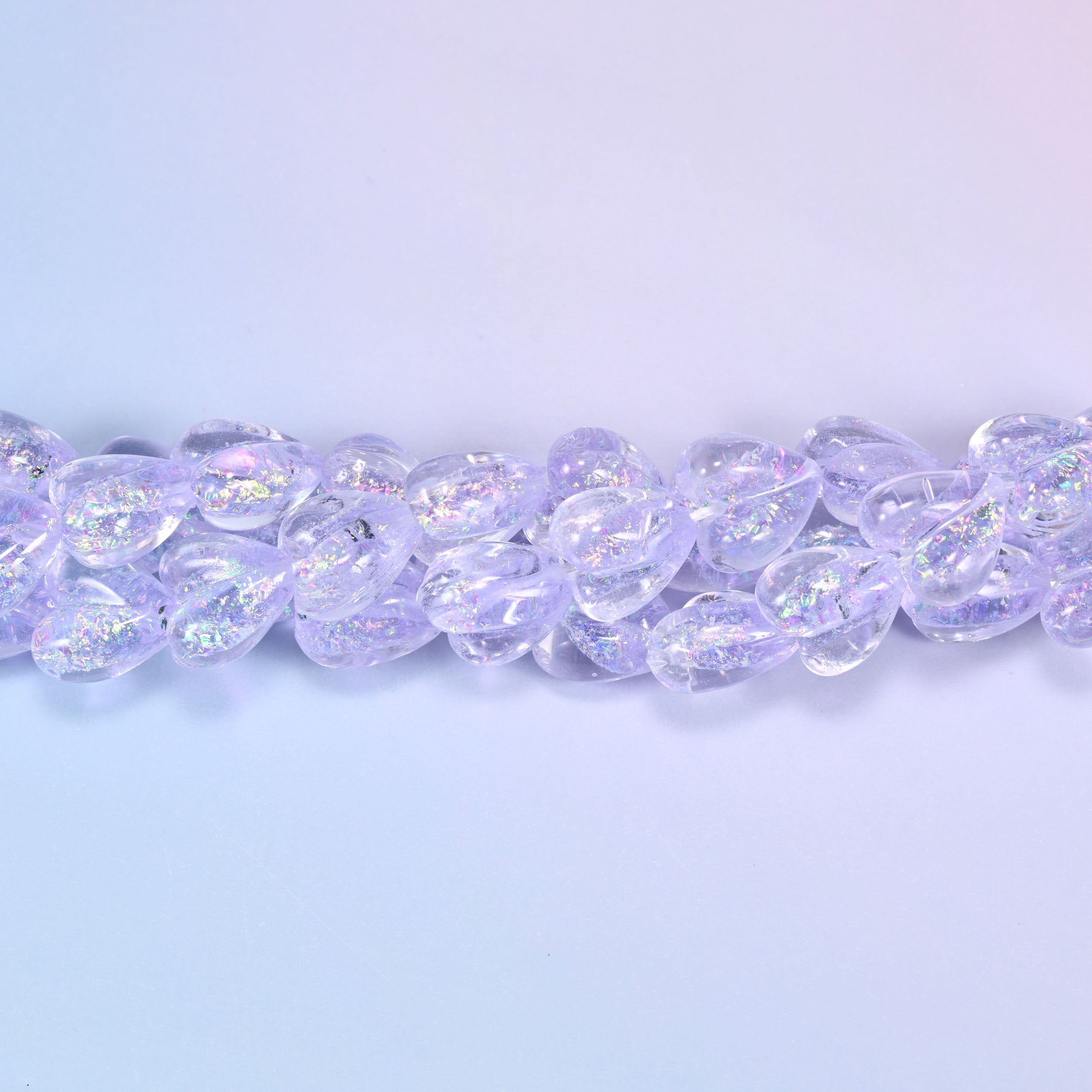Transparent pale lilac glass hearts with a glittering iridescent shimmer that throws pink and silver flashes