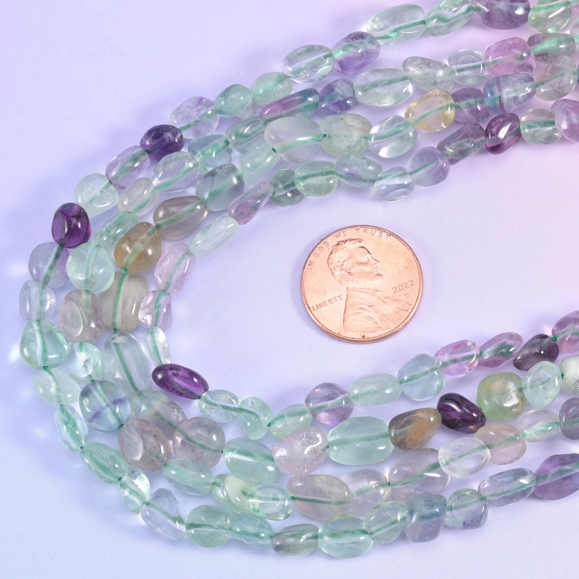 Fluorite nugget strands looped beside a US penny for size reference