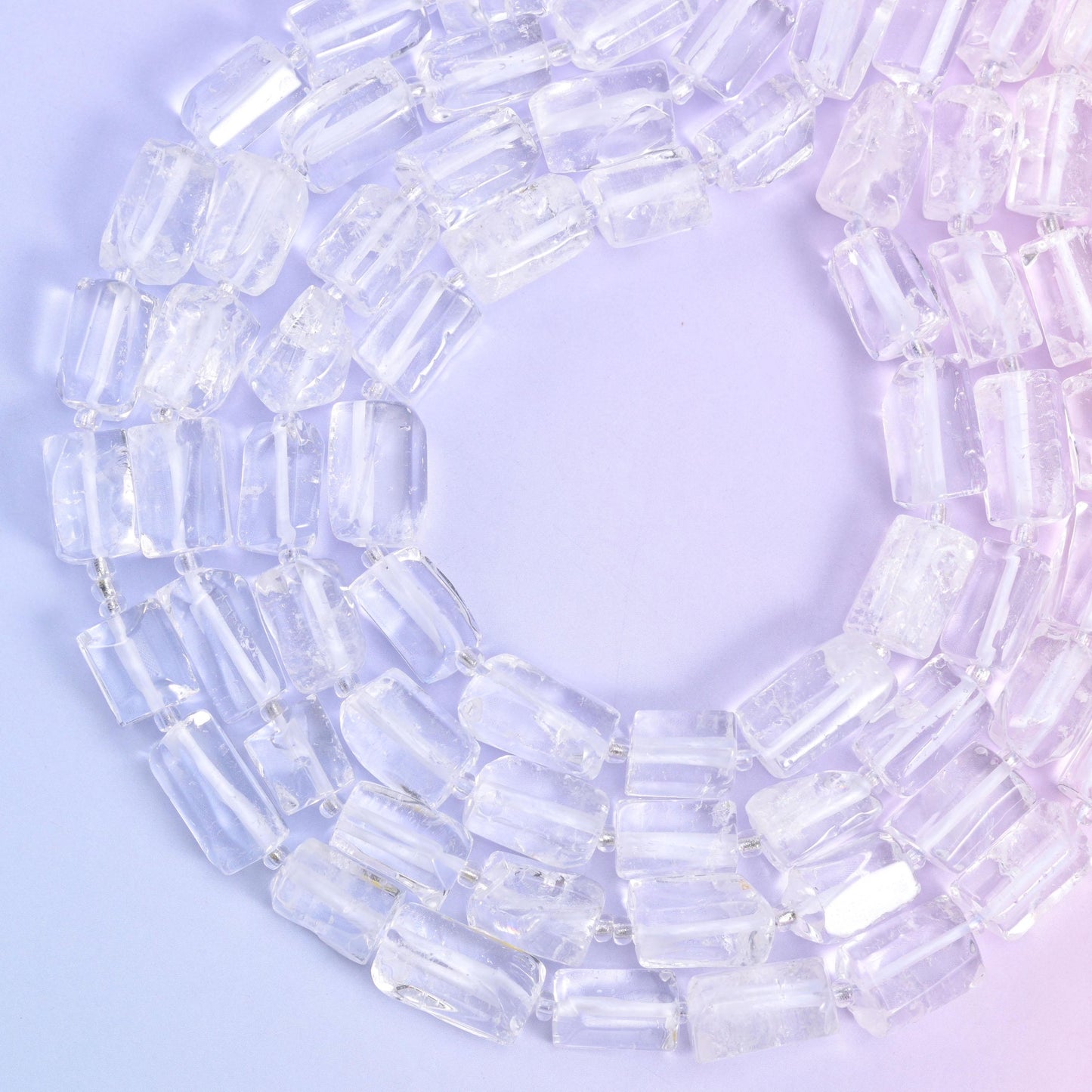 Open ring of strands laid out on lilac, the polished ends of each tube visible along the row