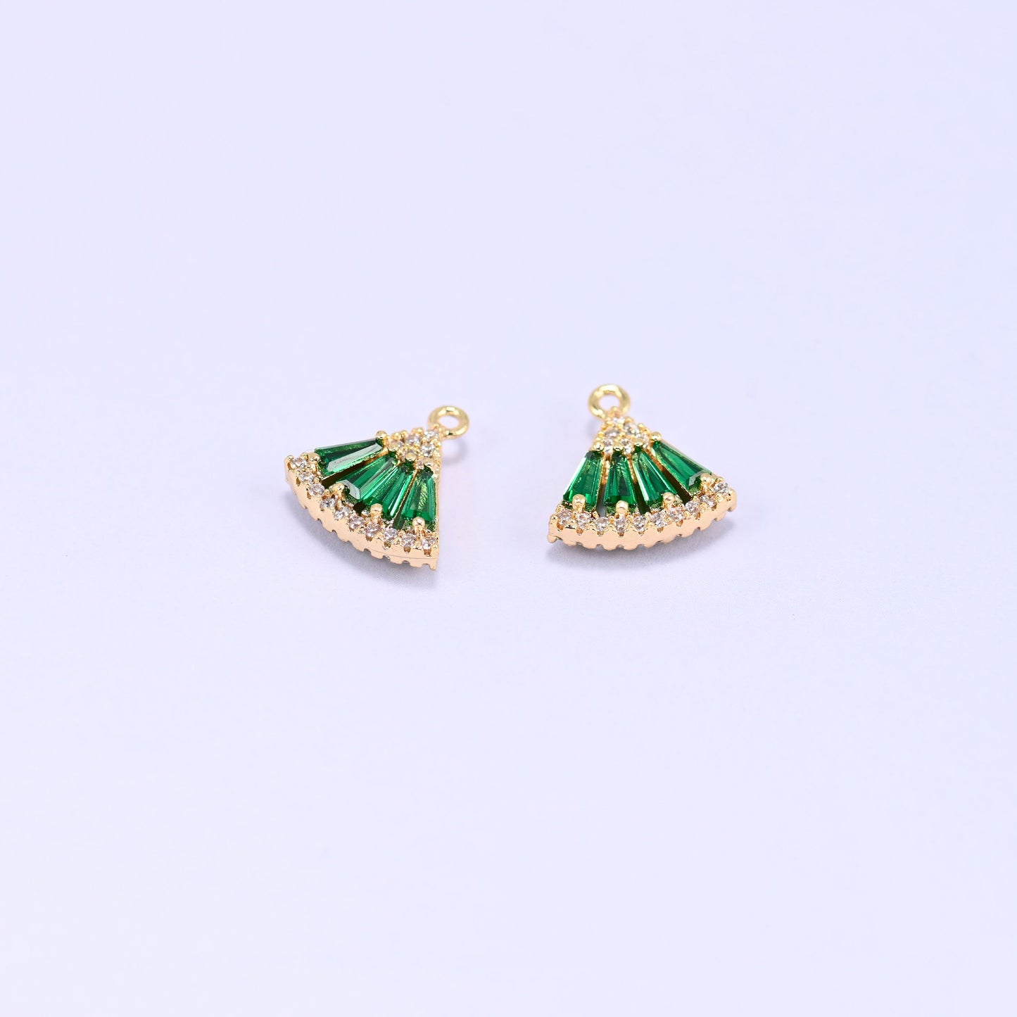 Small gold charms, two fan charms with green cubic zirconia shown close up