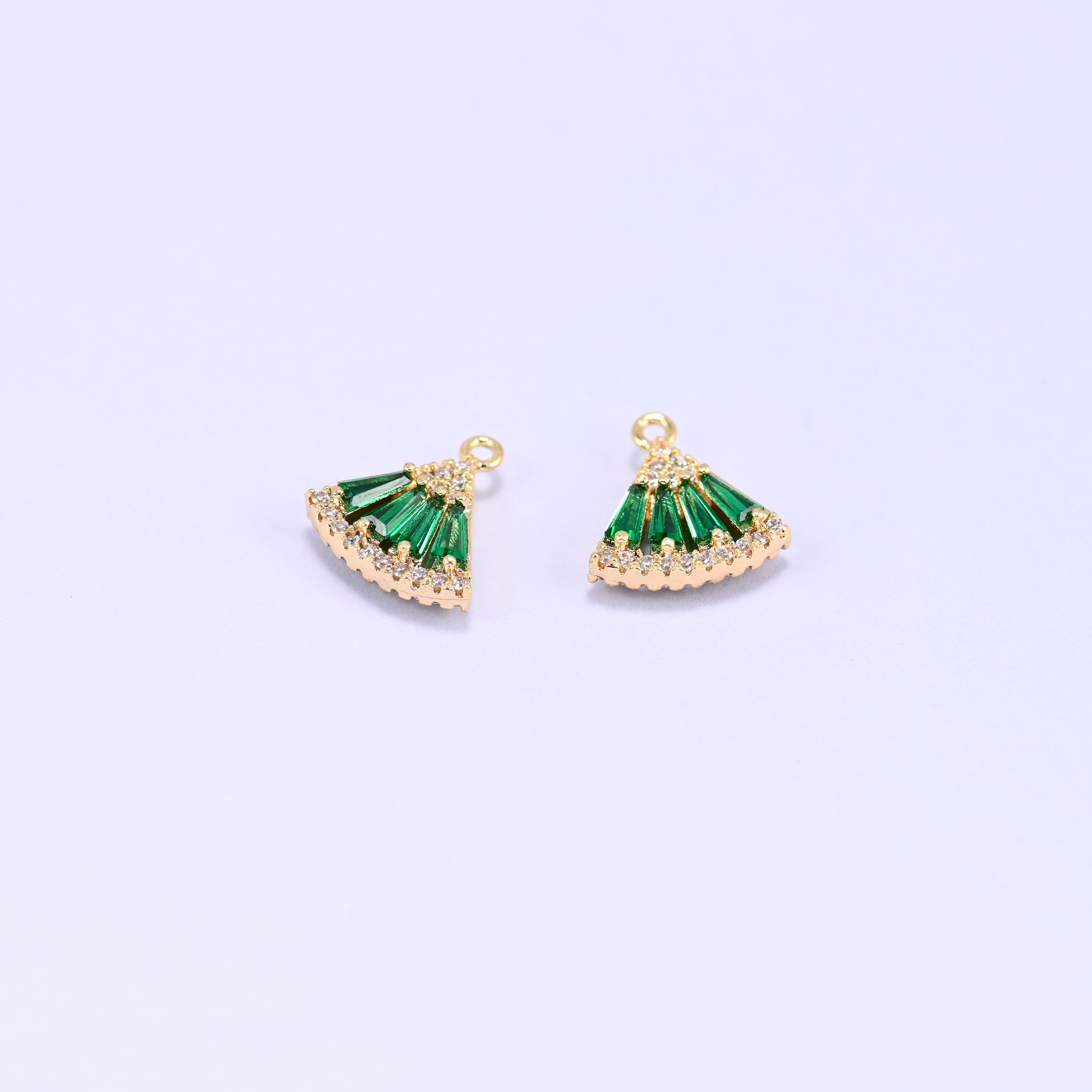 Small gold charms, two fan charms with green cubic zirconia shown close up
