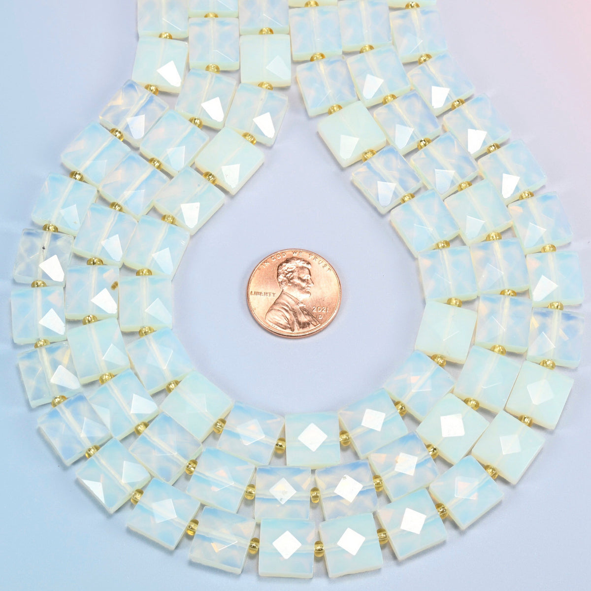 Opalite faceted flat square strands formed into a teardrop loop around a US penny for scale