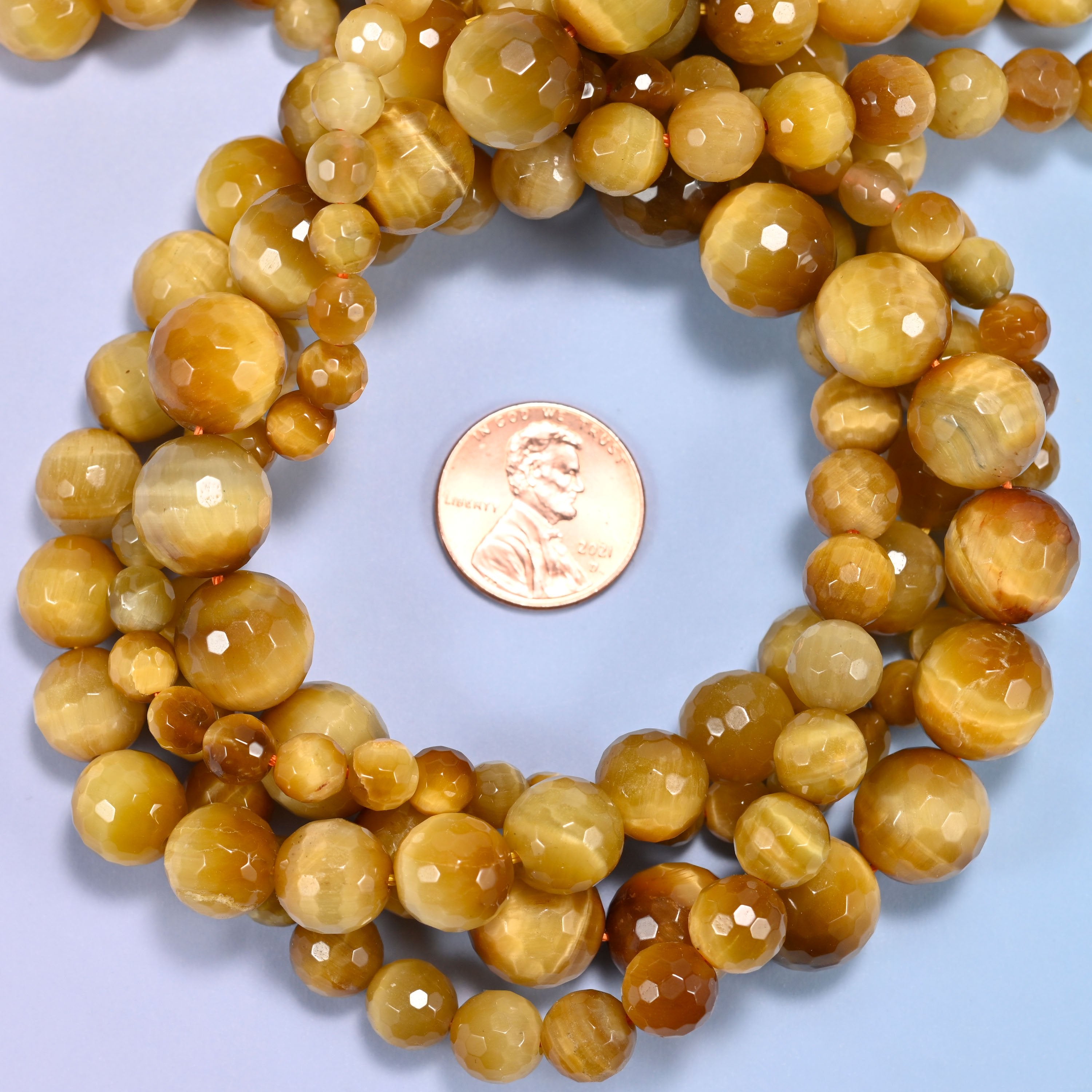 Close-up of golden brown gold tiger eye round beads, showing the faceted finish and natural brown tone.