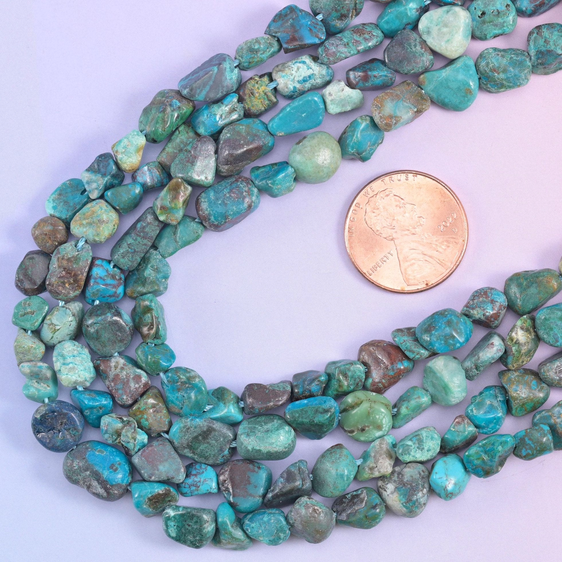 Strands looped beside a US penny, giving scale for the 6-8mm irregular nuggets