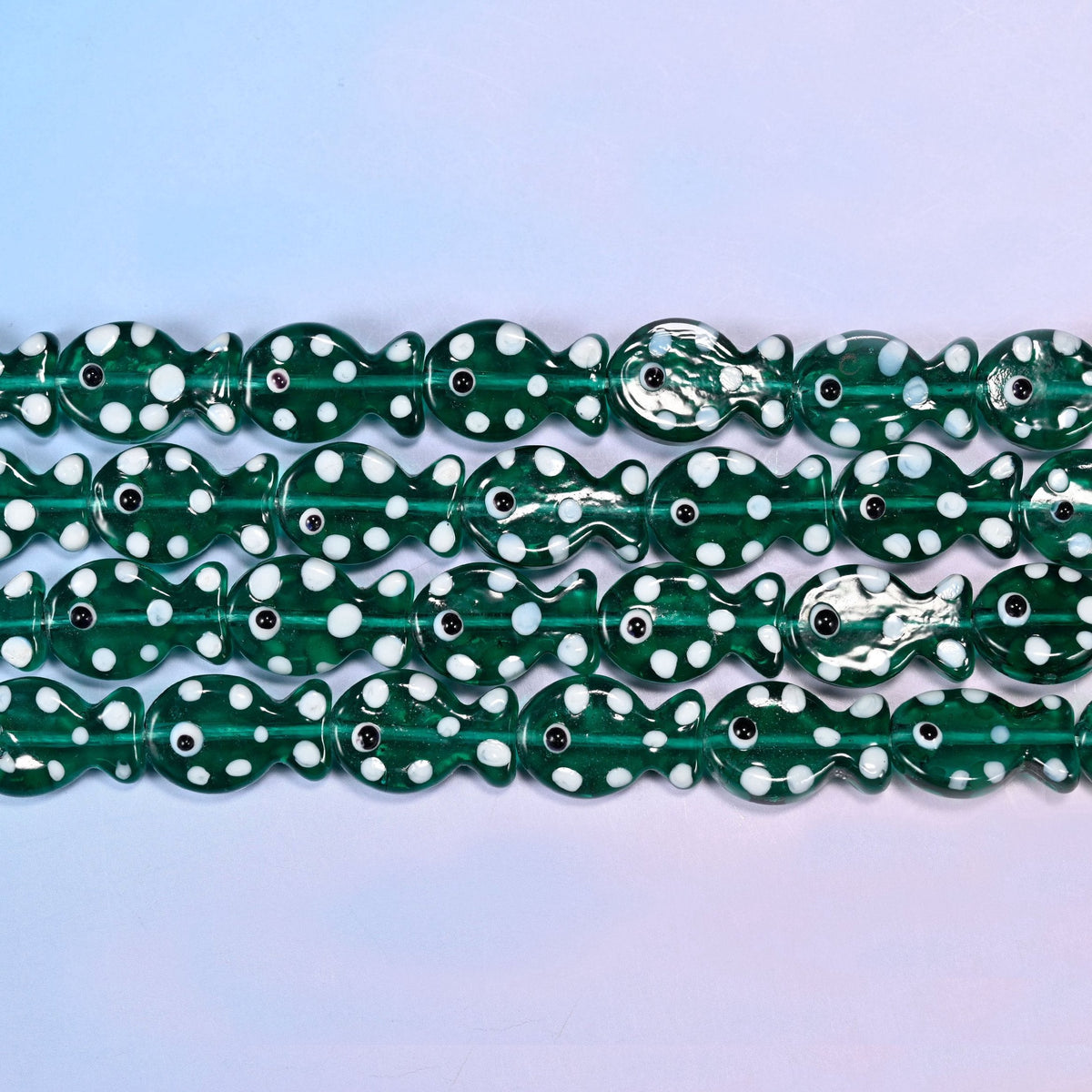 Fish glass beads in transparent deep bottle-green with white dots