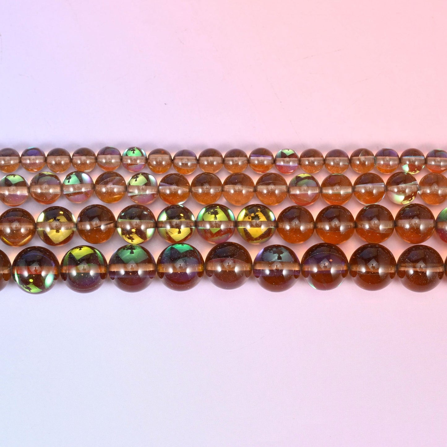 Mystic Aura Brown Round Glass Beads in clear smoky brown with a peacock-green and gold iridescent panel