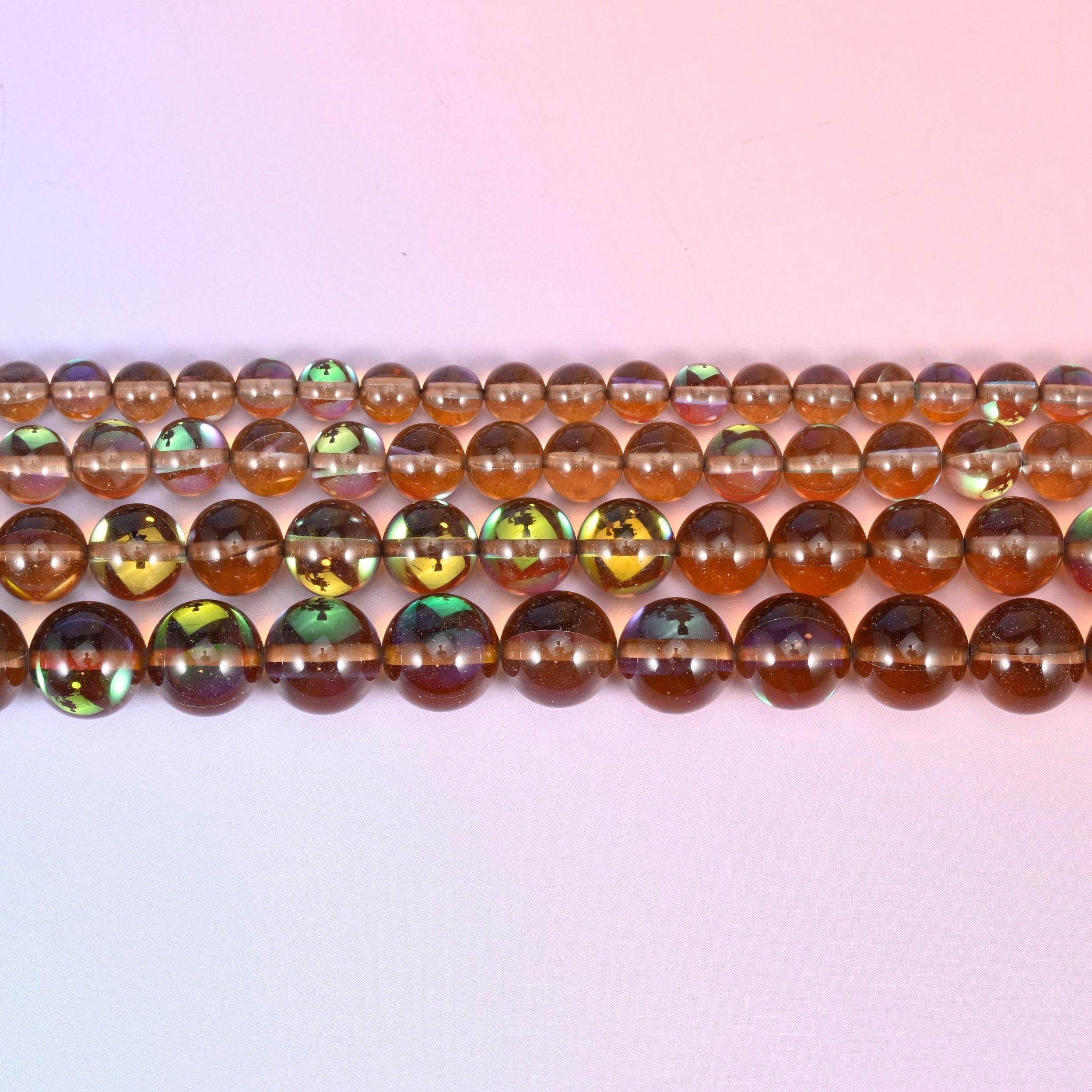 Mystic Aura Brown Round Glass Beads in clear smoky brown with a peacock-green and gold iridescent panel