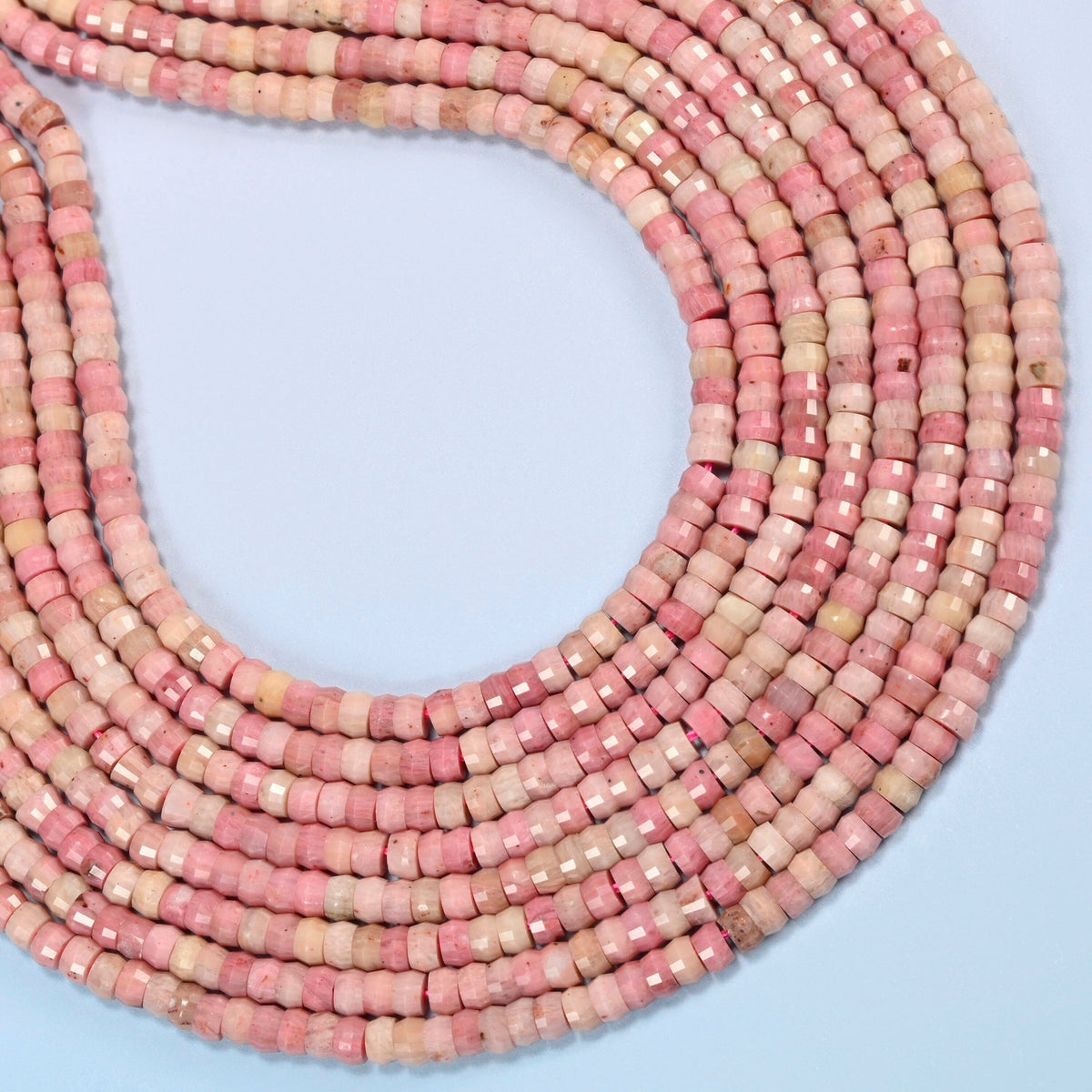 Pink rhodonite faceted heishi disc beads curved into an open loop, light pink and rose pink beads
