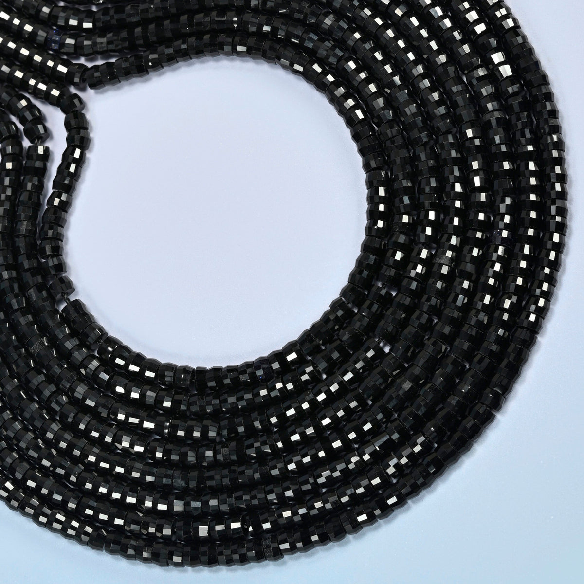Black onyx faceted heishi disc beads curved into an open loop, glossy black beads