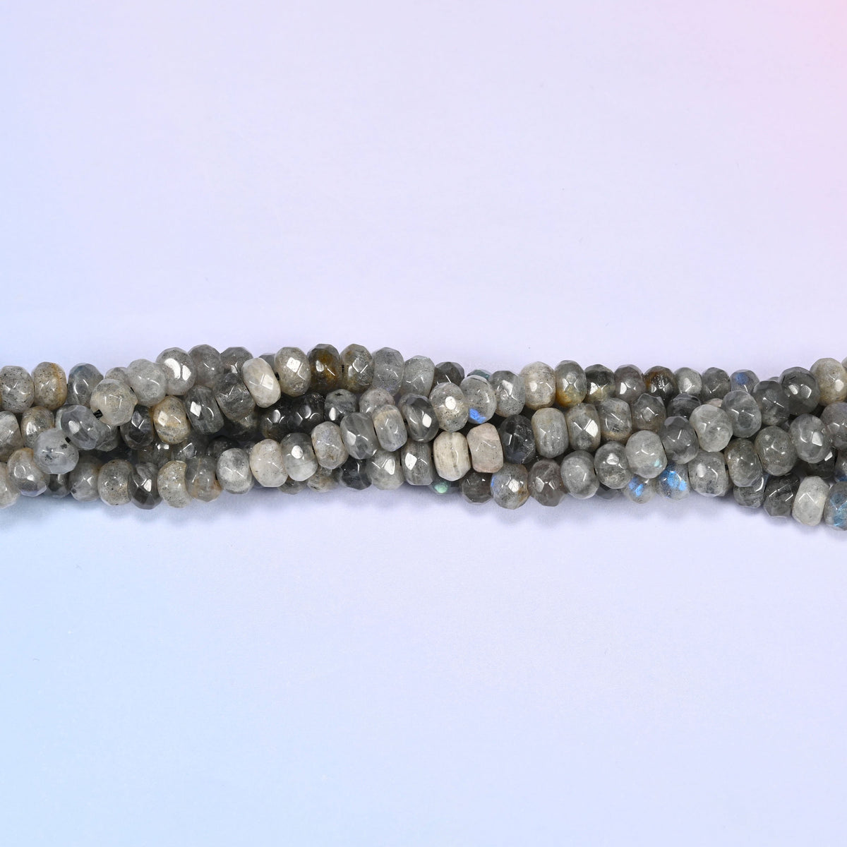 Gray Labradorite faceted rondelle beads in a single close run, the faceted edges catching light along the row