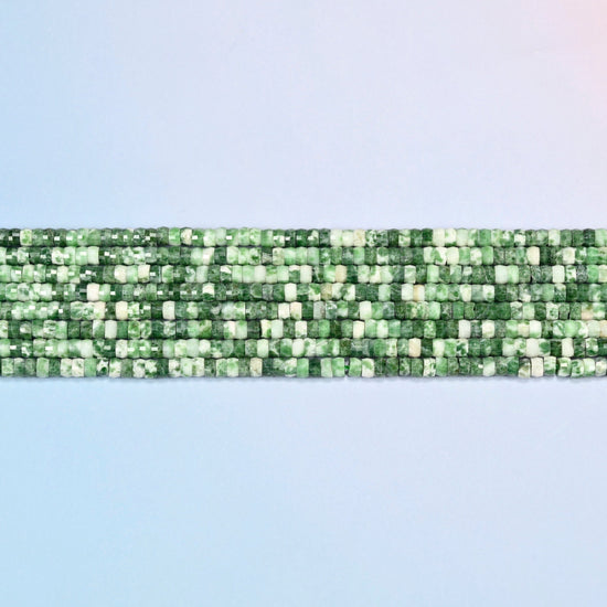 Several strands of tree agate faceted heishi disc beads laid in straight rows