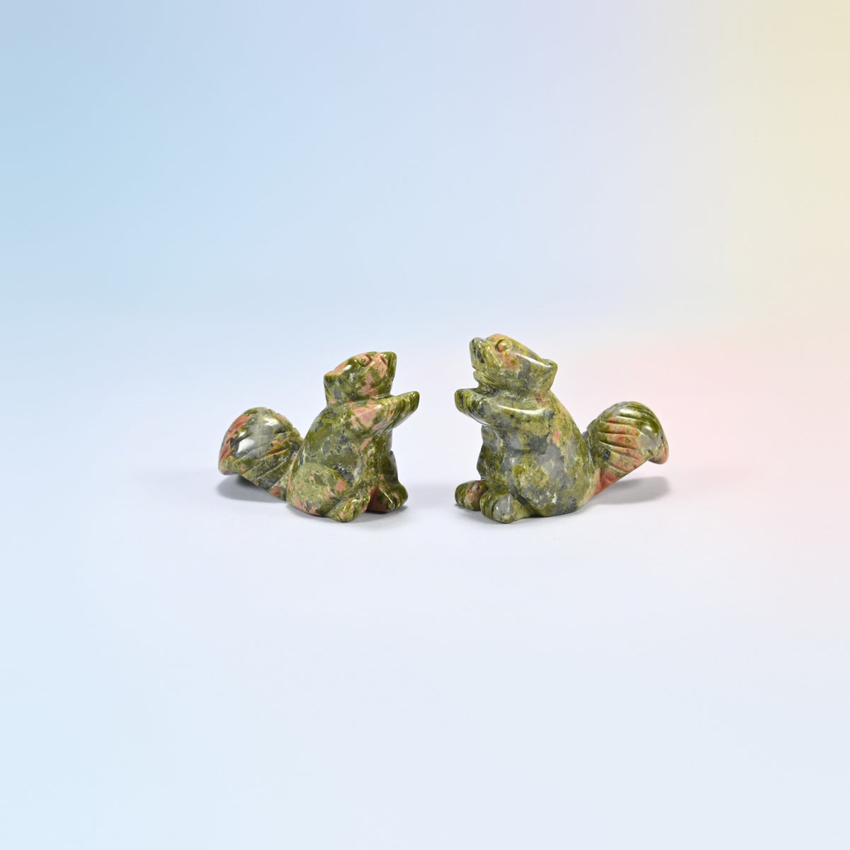 Two 2 inch natural unakite long tail squirrel carvings, mottled green and pink stone