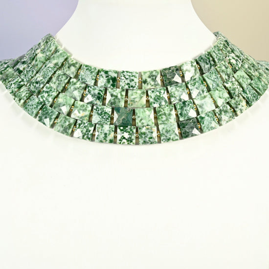 Tree agate faceted flat square strands arranged as a layered collar on a white display bust, green and white beads across the neck
