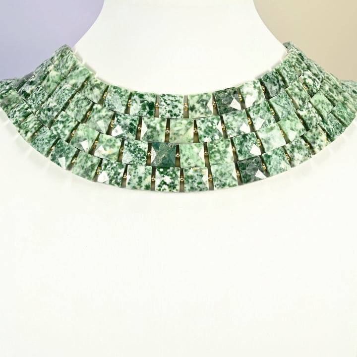 Tree agate faceted flat square strands arranged as a layered collar on a white display bust, green and white beads across the neck