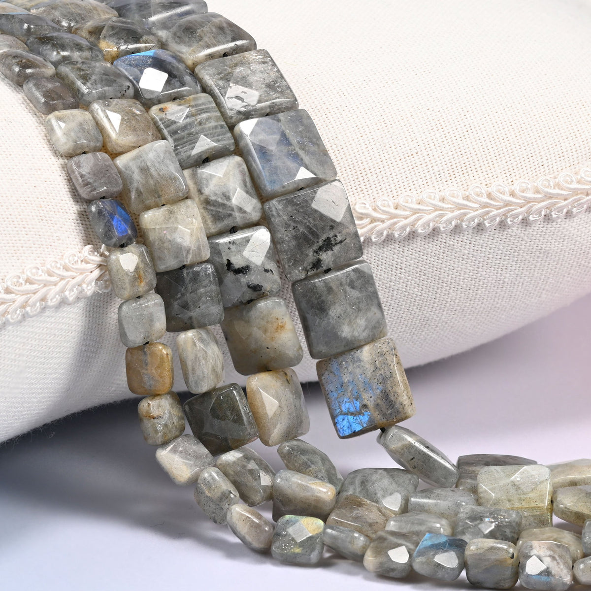 Gray Labradorite faceted flat square beads draped in a soft curve, flat tiles in mid gray with tan and gold streaking