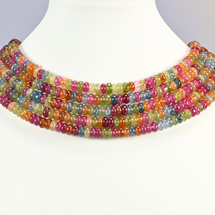 Tourmaline Color Dyed Jade smooth rondelle beads 3x6mm shown on a white display neck form, four strands of mixed rose pink, warm orange, olive green and teal blue