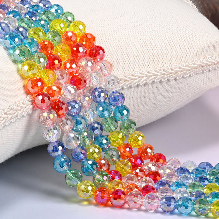 Colorful faceted round glass beads draped over a cushion, 8mm transparent beads in blue, green, yellow, orange, red, pink, clear and purple
