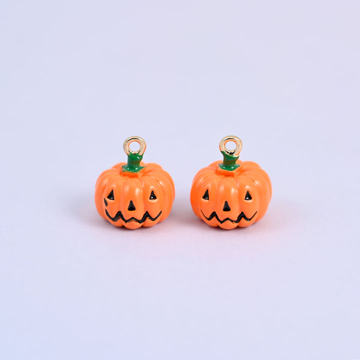 Two enamel pumpkin charms side by side, both showing the black jack o lantern face on the orange enamel body.