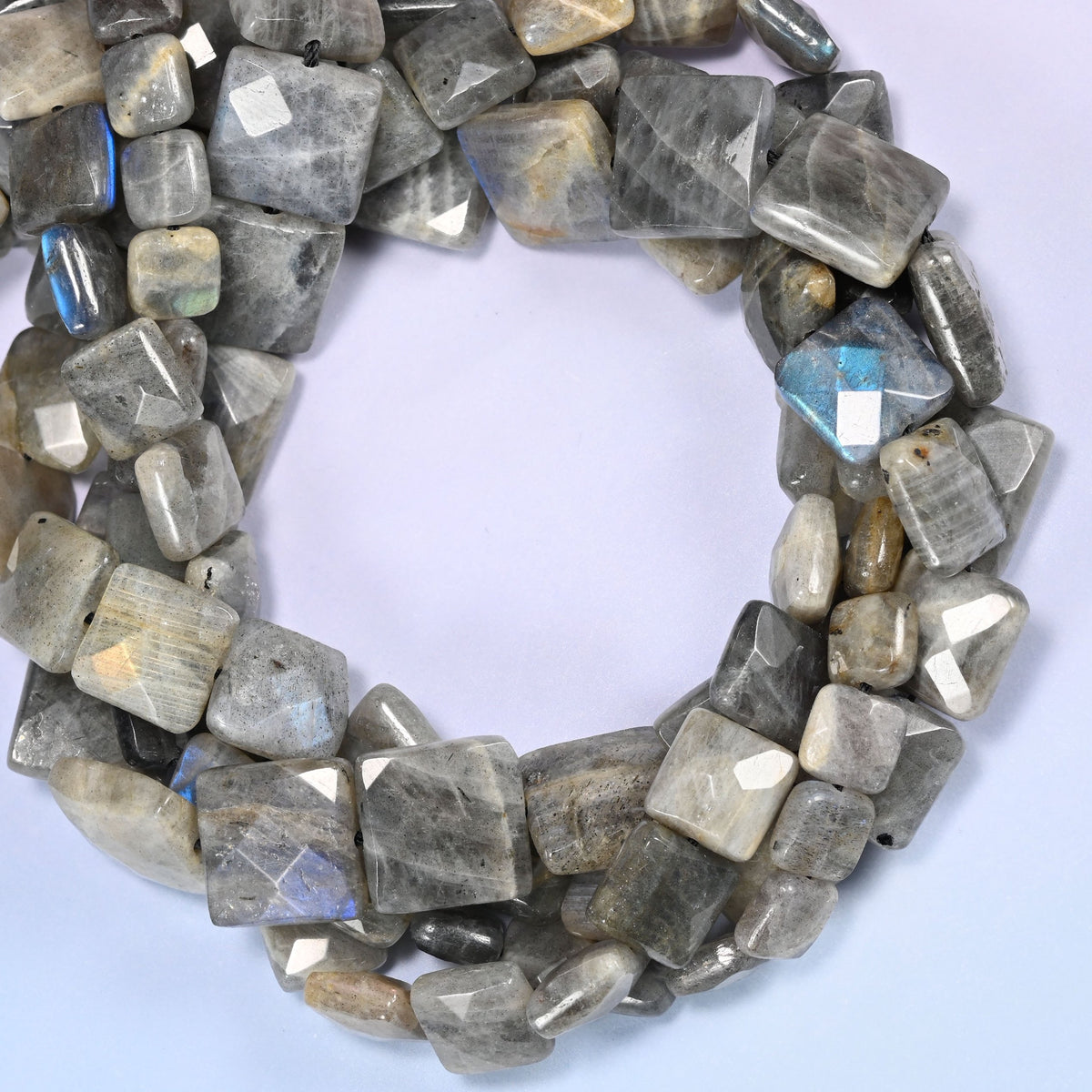 Gray Labradorite faceted flat square beads coiled tight, near-white tiles sitting beside charcoal ones on the same strand