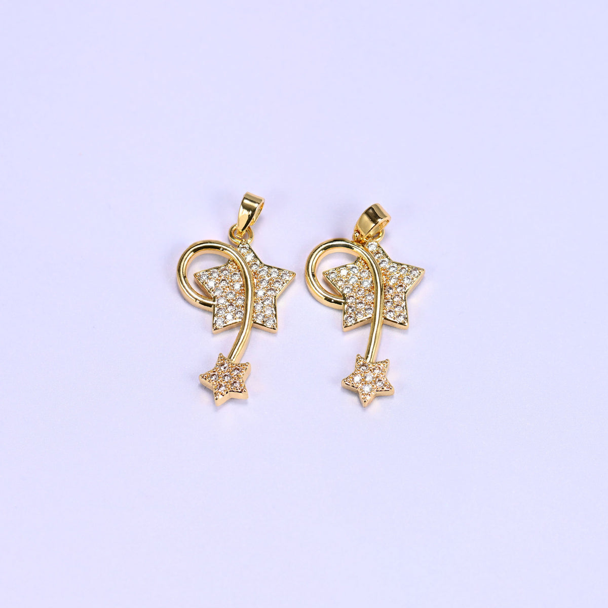 Two 18K gold plated wishing star zirconia charms side by side, each with a pave star, swirling wire trail and small trailing star.