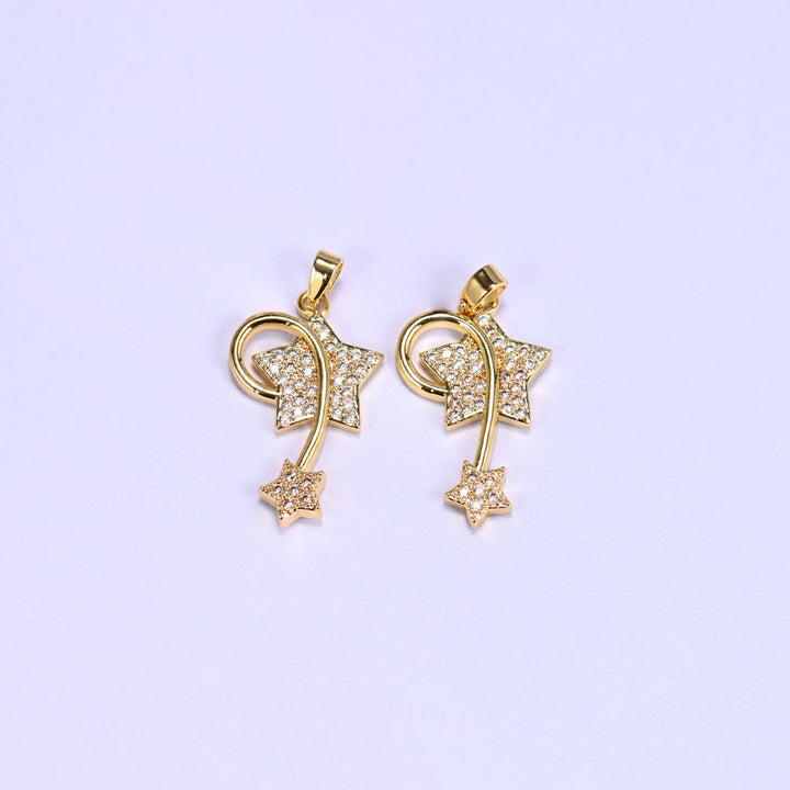 Two 18K gold plated wishing star zirconia charms side by side, each with a pave star, swirling wire trail and small trailing star.