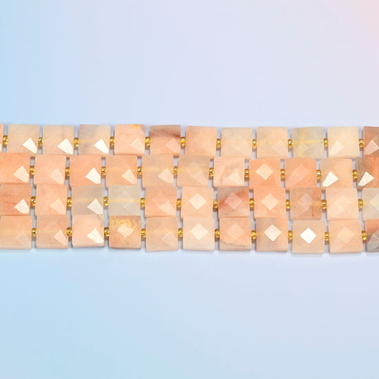Several strands of natural pink aventurine faceted flat square beads laid in straight rows