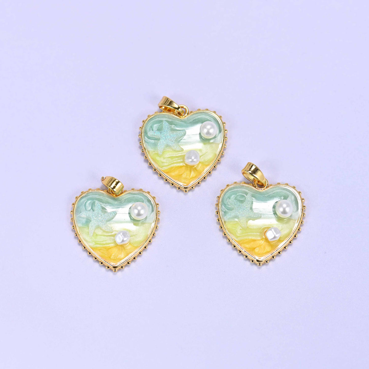 Enamel Heart Pendants in green, three charms shown together with green-to-yellow ombre enamel, a glittery starfish and small faux pearl accents.