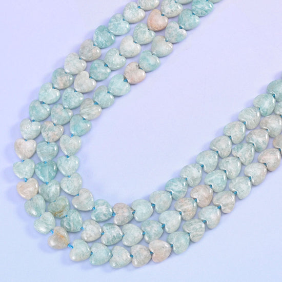 Blue Amazonite heart strands curving in a wide U on a lilac background