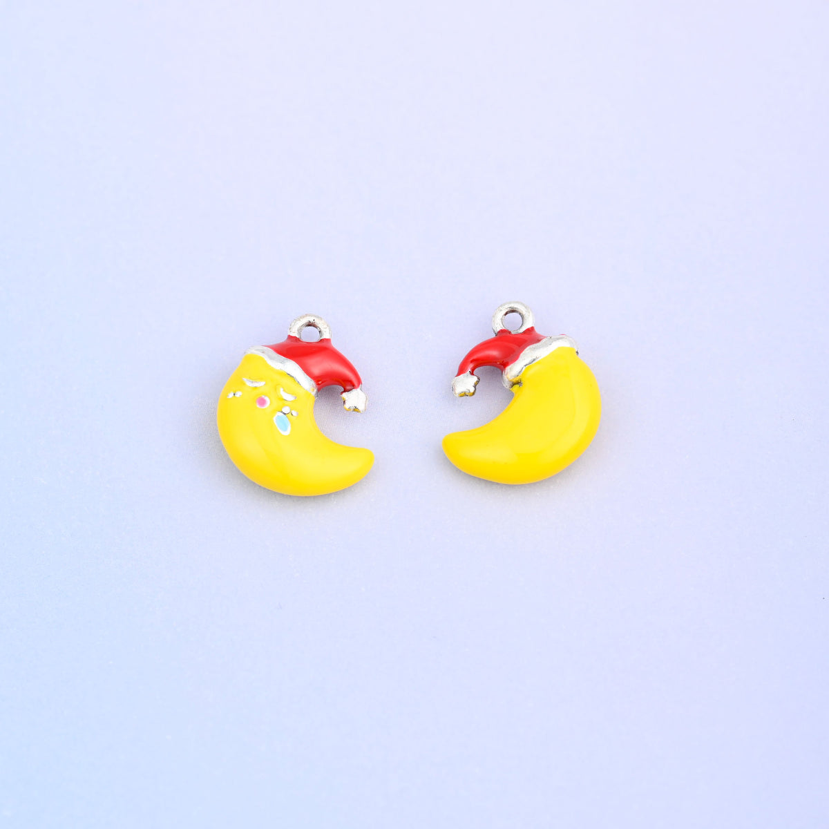 Two yellow crescent moon charms in red Santa hats, one showing the sleeping face.